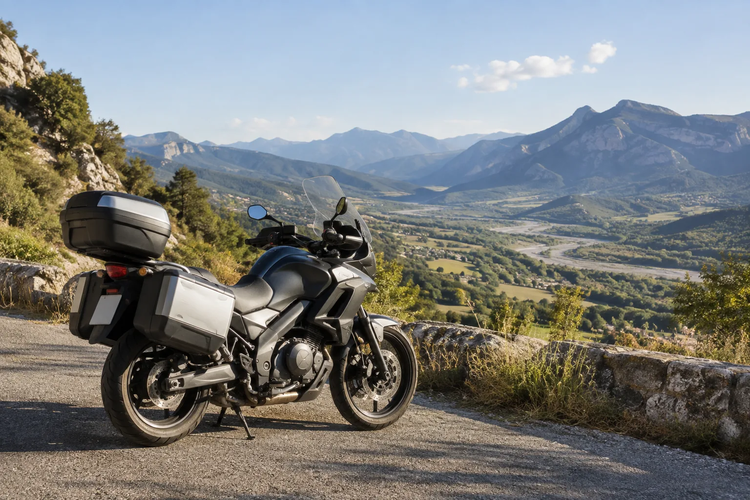Une moto arrêtée sur une route du pays dignois, face aux reliefs de la vallée de la Bléone.