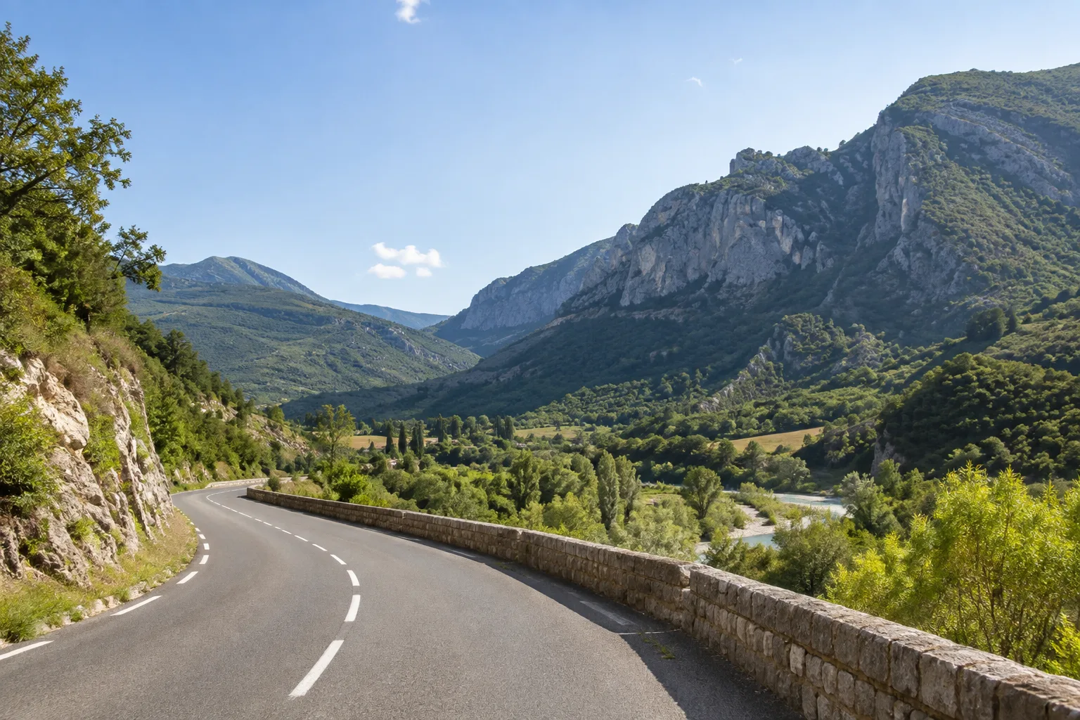 Route de vallée près d’Estoublon, bordée de reliefs calcaires et de végétation provençale.
