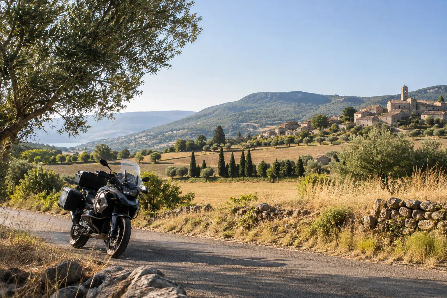 Une moto arrêtée sur une route secondaire du pays de Riez, devant des champs et des collines provençales.
