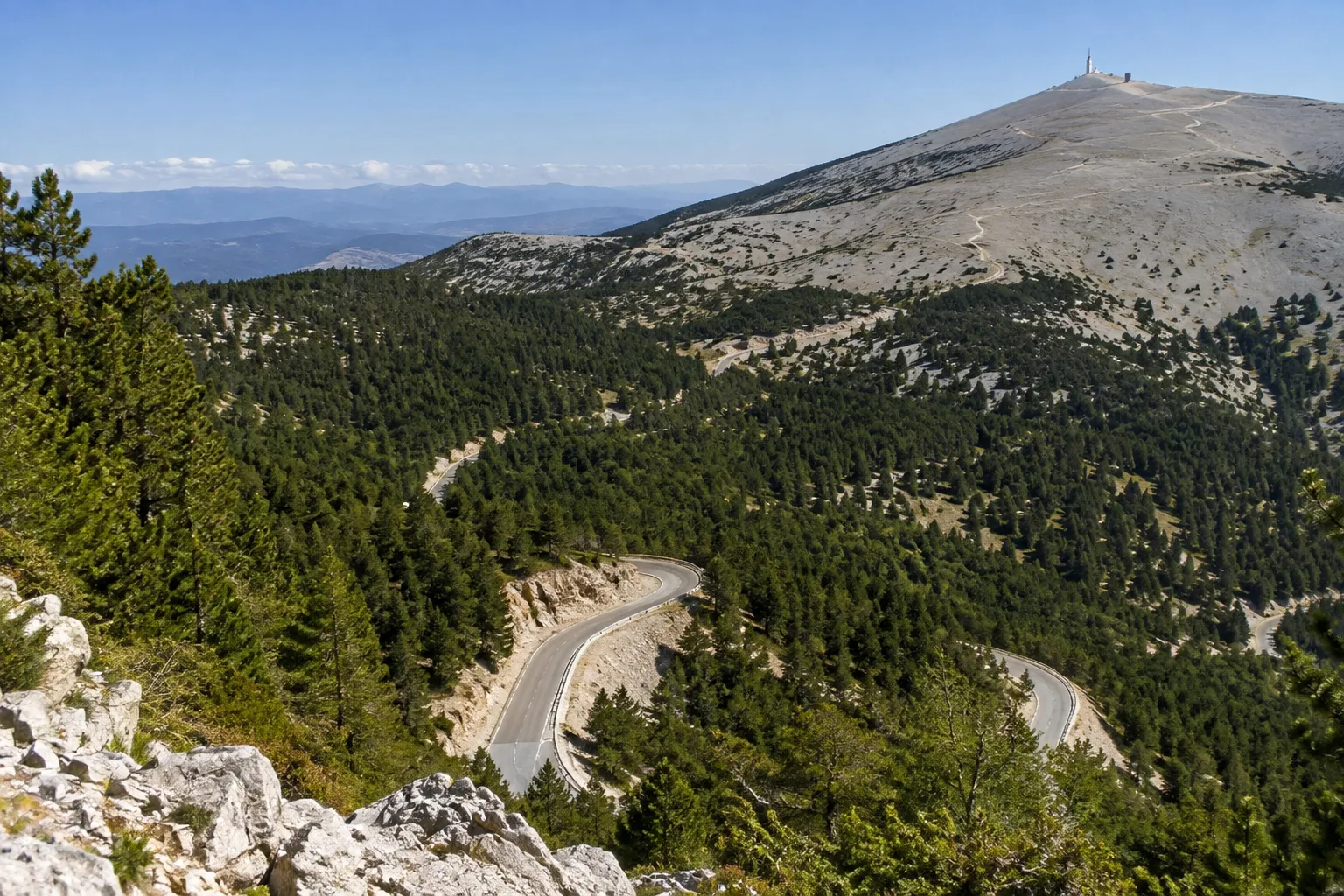 Une route sinueuse traverse les bois du versant sud avant de rejoindre les pentes minérales du Ventoux.